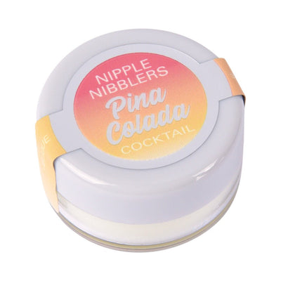 Small white jar of Jelique Pina Colada flavored nipple nibblers balm with gradient pink and yellow label on lid.
