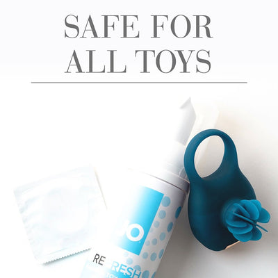 Travel size JO Foaming Toy Cleaner bottle with a blue silicone ring toy and a condom packet on a white background.