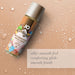 Bottle of JO Candy Shop Butterscotch flavored water-based personal lubricant on a beige background with water droplets and text describing its silky-smooth feel and comforting glide.