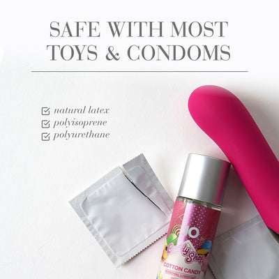 Pink JO H20 Cotton Candy flavored lubricant bottle with condom packets and a pink silicone toy on white background.
