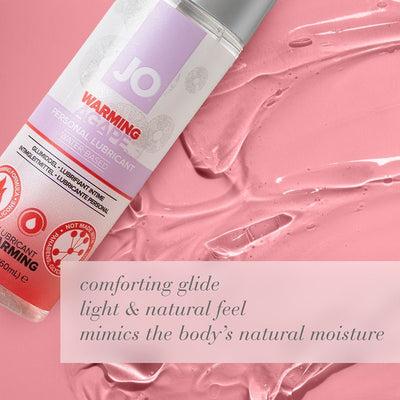 Bottle of Jo Natural Agape Warming water-based personal lubricant on pink textured background with product benefits text.