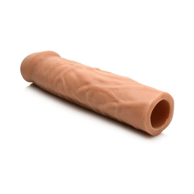Medium-sized flesh-toned flexible penis extension sleeve with textured surface and hollow core.