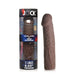 Jock extra long 3-inch penis extension sleeve in medium brown with lifelike texture next to its clear cylindrical packaging.
