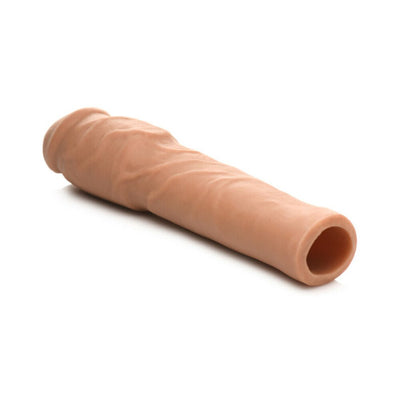 Medium-sized flesh-toned flexible penis extension sleeve with realistic texture and hollow core on white background.
