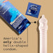 Kimono Swirl condom packaging with single blue foil packet and transparent double helix-shaped condom on beige background.