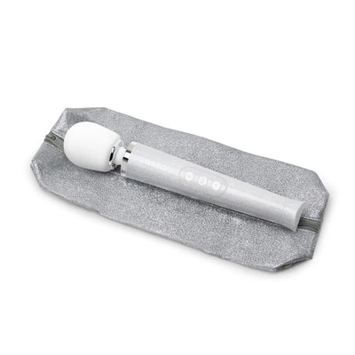 Le Wand Petite rechargeable massager wand in silver glitter finish resting on a matching silver glitter zippered pouch.