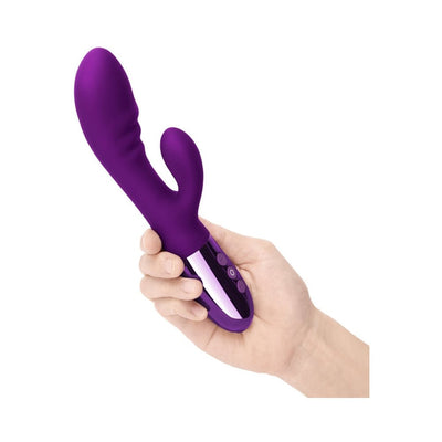 Hand holding a purple Le Wand Blend double-motor rabbit vibrator with curved design and control buttons on the handle.