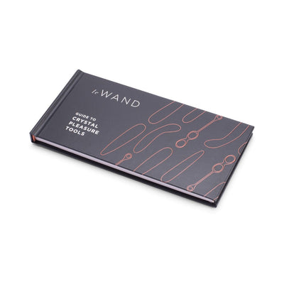 Le Wand hardcover guidebook titled Guide to Crystal Pleasure Tools with abstract line art on cover, lying flat on white background.