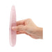 Hand holding a smooth, slim rose quartz crystal wand with a tapered tip against a white background.