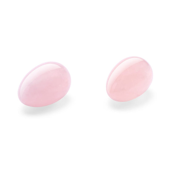 Set of two polished rose quartz yoni eggs with smooth, oval shapes on a white background.