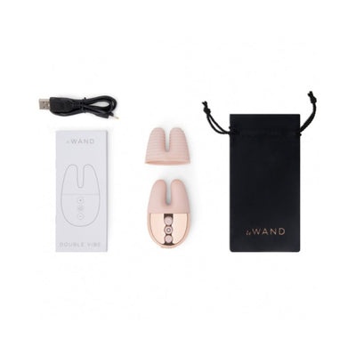 Le Wand Double Vibe with USB charging cable, textured silicone sleeve, user manual, and black travel pouch on white background.