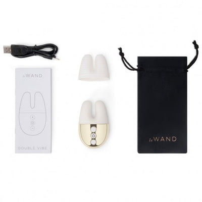 Le Wand Double Vibe with USB charging cable, extra silicone sleeve, user manual, and black travel pouch on white background.