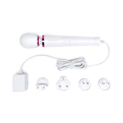 Le Wand Powerful Petite Plug-in massager with flexible head, long cord, and four interchangeable plug adapters on white background.