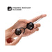 Hands holding glossy black LELO Beads Noir with a silicone harness and easy-to-clean label on white background.