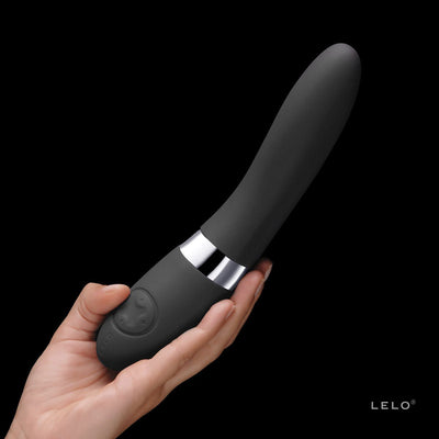 Hand holding a sleek black LELO Elise 2 vibrator with a smooth silicone surface and control buttons on the base.