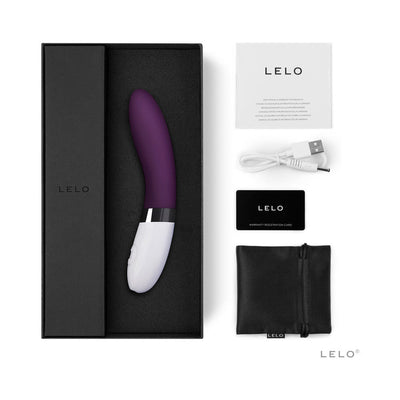 Lelo Liv 2 purple and white personal massager with USB charging cable, storage pouch, warranty card, and user manual in black box.