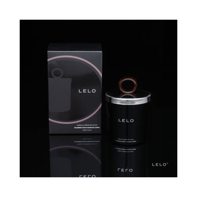 Lelo Massage Candle in black glass jar with silver lid and wooden handle next to matching black and pink packaging box on reflective surface.