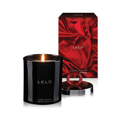 Lelo Massage Candle in black glass with lit wick, silver lid with red ring, and red silk-themed packaging behind.
