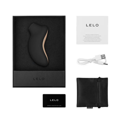 Lelo Sona Cruise clitoral stimulator in black with rose gold accents, USB charging cable, storage pouch, manual, and warranty card in packaging.