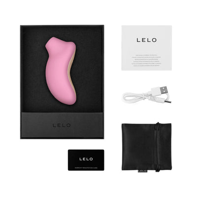 Lelo Sona Cruise clitoral stimulator in pink with USB charging cable, storage pouch, warranty card, and user manual in black box packaging.