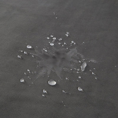 Close-up of dark gray waterproof microvelvet fabric with water droplets beading on the surface.