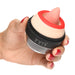 Hand holding a compact Lickgasm Lady Licker clitoral stimulator with red lips and a textured pink silicone tongue.