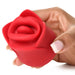 Hand holding a red silicone rose-shaped clitoral stimulator with soft, curved petals and a compact design.