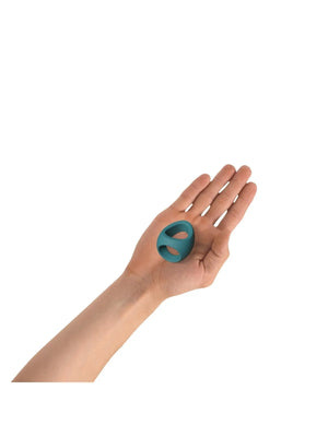 Hand holding a teal double silicone cockring designed for comfort and enhanced pleasure.