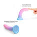 Glow-in-the-dark pink and blue silicone dildo with flexible curve and suction cup base shown with finger for scale.
