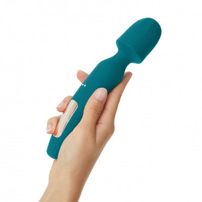 Hand holding a teal rechargeable wand vibrator with a smooth rounded head and ergonomic design.
