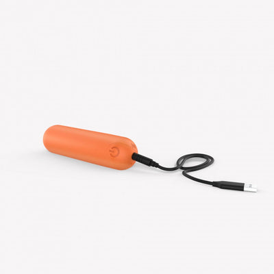 Orange compact rechargeable bullet vibrator with USB charging cable on white background