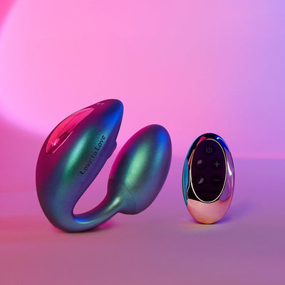 Love To Love Wonderlover flexible silicone stimulator with LED display and matching remote control on pink and purple background.