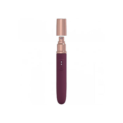 Compact rechargeable travel vibrator in deep plum with rose gold accents and a smooth silicone finish.