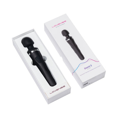 Lovense Domi 2 black wand vibrator displayed in open white box alongside its packaging box on a white background.