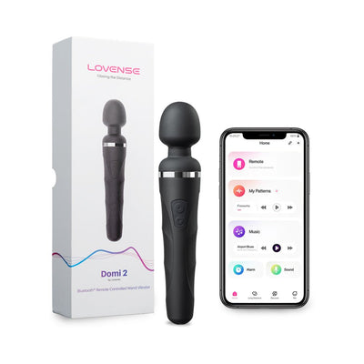 Lovense Domi 2 black wand vibrator with packaging and smartphone showing app control interface.
