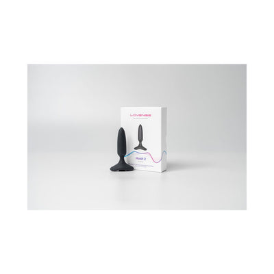 Lovense Hush 2 black silicone butt plug with flared base next to its white retail box on a plain background.