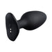 Black Lovense Hush 2 app-compatible silicone butt plug with smooth, tapered design and magnetic charging base.