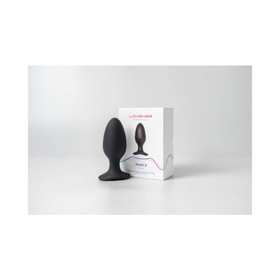 Lovense Hush 2 black silicone butt plug with flared base displayed next to its white packaging box on a white surface.