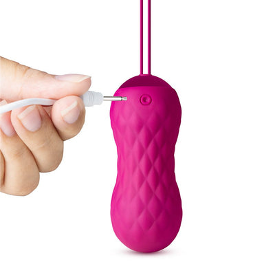 Hand plugging USB charger into textured pink Lush Carina insertable bullet vibrator with pull loop.