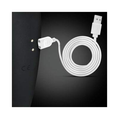 White magnetic USB charging cable next to black device with two metal charging contact points.