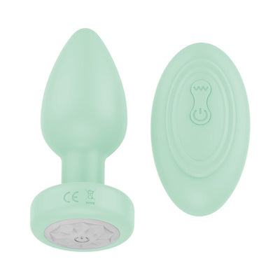 Mint green vibrating plug with matching remote control, both made of smooth silicone with power buttons visible.