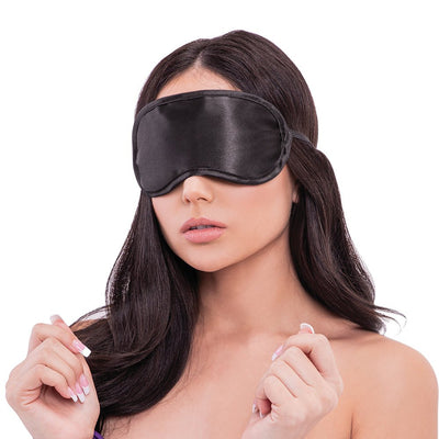 Woman wearing a smooth black satin blindfold from the Lux Fetish Hogtie & Ball Gag 7-piece Kit.