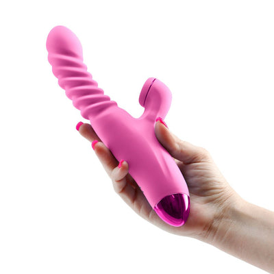 Hand holding a pink Luxe Nova dual stimulator with textured shaft and curved clitoral attachment against a white background.