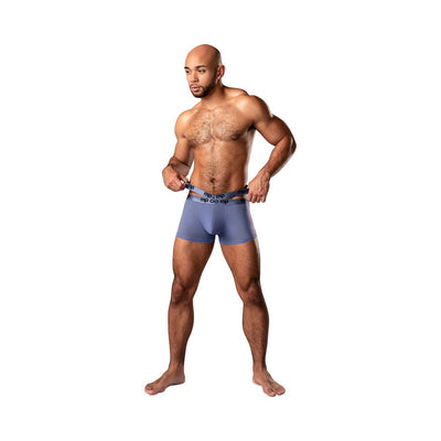Athletic man wearing periwinkle Male Power Amplifying Strappy Pouch shorts with double logo waistbands on white background.