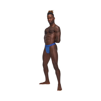 Athletic man modeling blue Male Power Sexagon Micro V Thong with hexagon pattern and branded waistband on white background.
