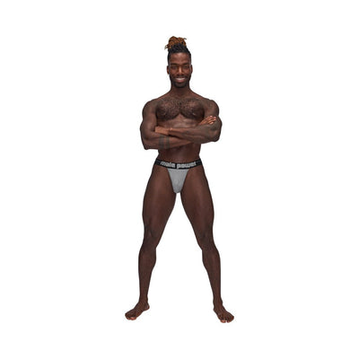 Male model wearing Male Power Sexagon Strappy Ring Jock with hexagon print and branded elastic waistband, standing with arms crossed.