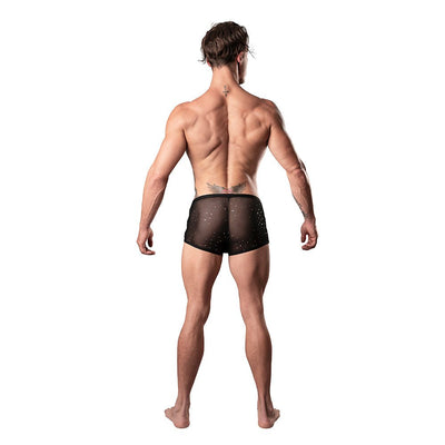 Back view of a man wearing black sheer mini shorts with silver dots, showcasing a low-cut waist and high-cut legs.