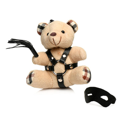 Plush teddy bear keychain with plaid ears, black faux leather harness, mini flogger, and removable black eye mask.