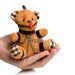Hand holding a small brown teddy bear keychain with plaid ear and paw details, wearing black faux leather straps, chains, and a red ball gag.