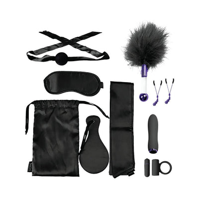 Black satin BDSM set with blindfold, ball gag, feather tickler, nipple clamps, vibrator, paddle, straps, and storage bag.